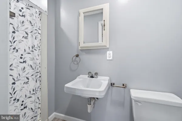 a bathroom with a sink a toilet and mirror