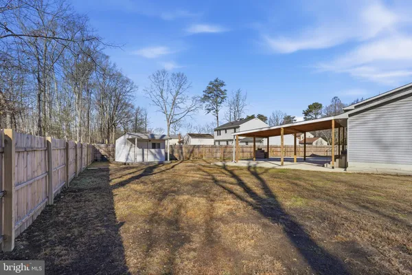 a view of a house with backyard and trees