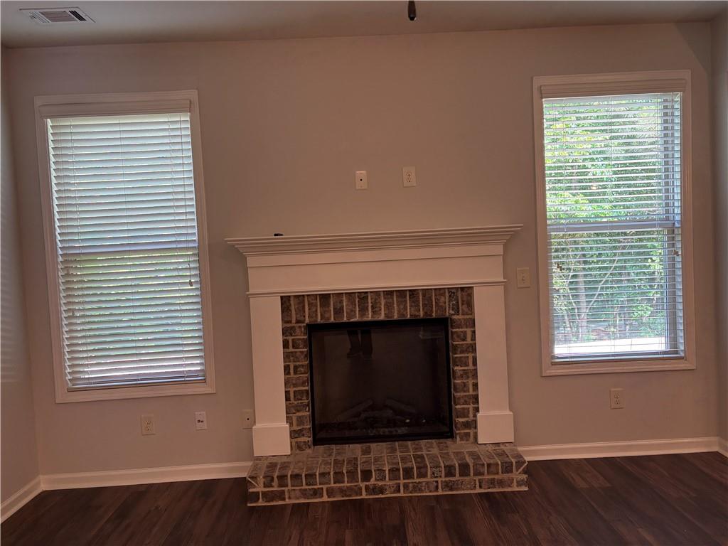 5934 Watersdown Way Flowery Branch, GA 30542 - Photo 7 of 28 a living room with a fireplace and windows