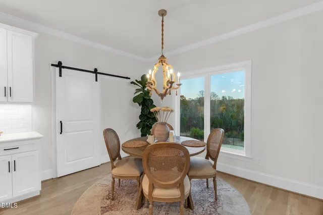 a dining room with furniture a potted plant and wooden floor