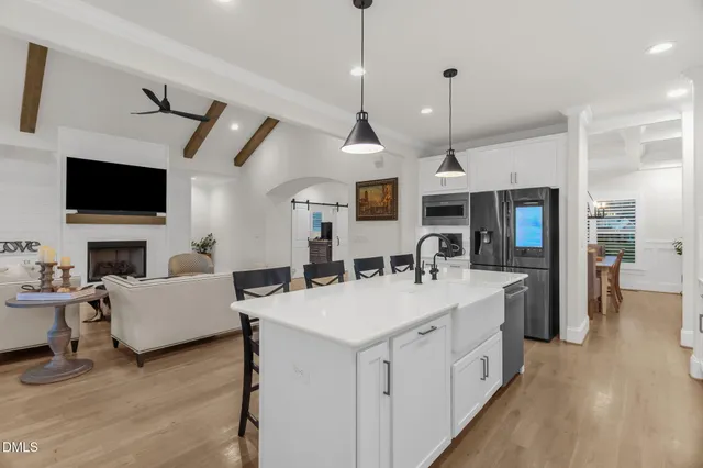 a view of living room kitchen with stainless steel appliances furniture stove and living room view