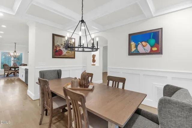a view of a dining room with furniture wooden floor and a chandelier
