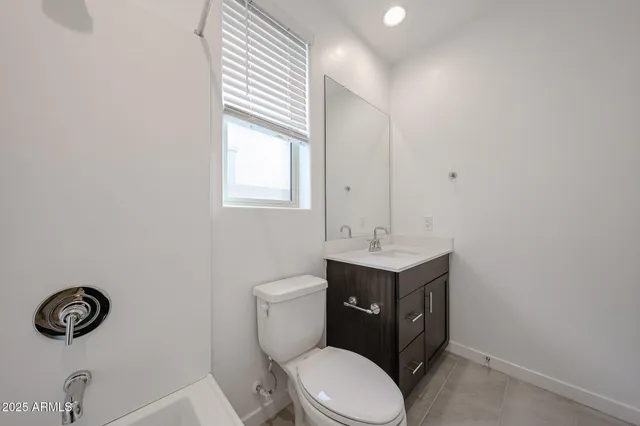 a bathroom with a toilet a sink and mirror