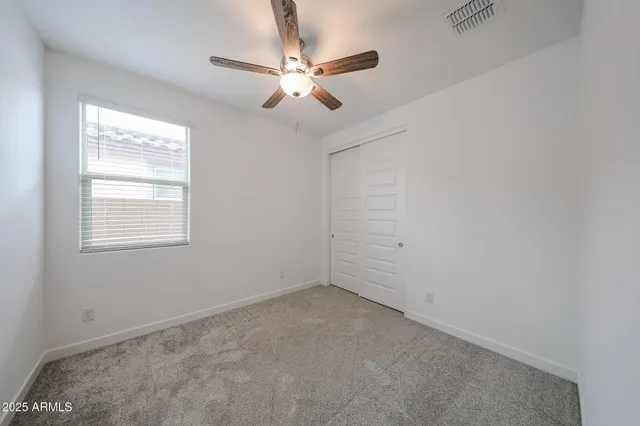 an empty room with a window and a fan