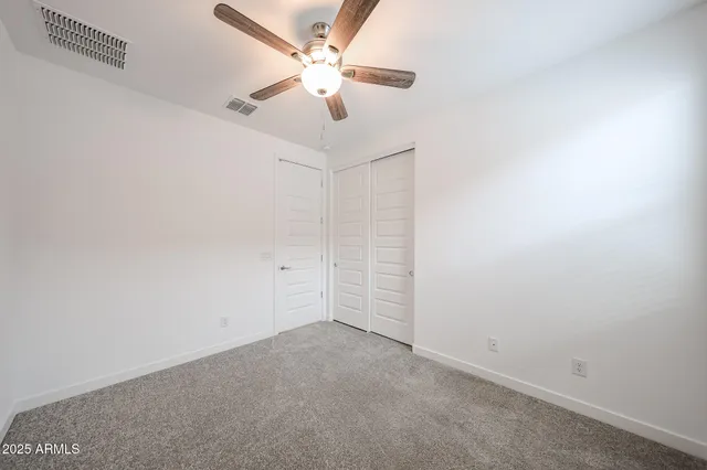 an empty room with a ceiling fan and a window