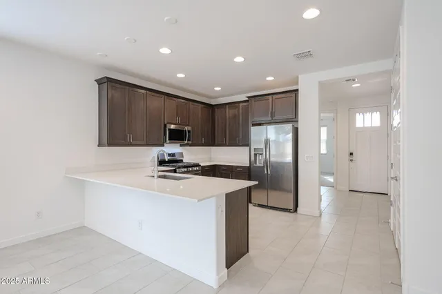 a kitchen with stainless steel appliances granite countertop a sink and a refrigerator