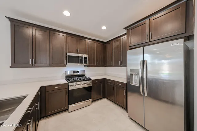 a kitchen with granite countertop stainless steel appliances and a refrigerator
