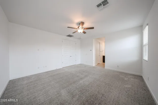 an empty room with a ceiling fan and a ceiling fan