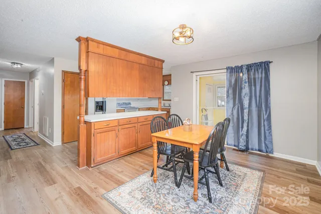 a dining room with a table chairs and a kitchen view