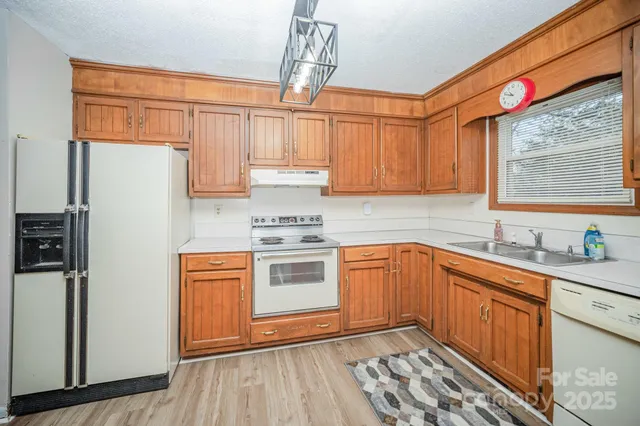 a kitchen with stainless steel appliances granite countertop a sink a stove and refrigerator