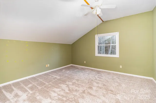 an empty room with a window and a ceiling fan