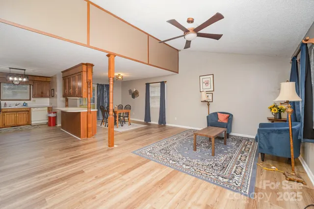a view of a living room and kitchen with furniture and wooden floor