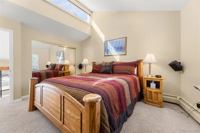 a bedroom with a bed and a painting on the wall