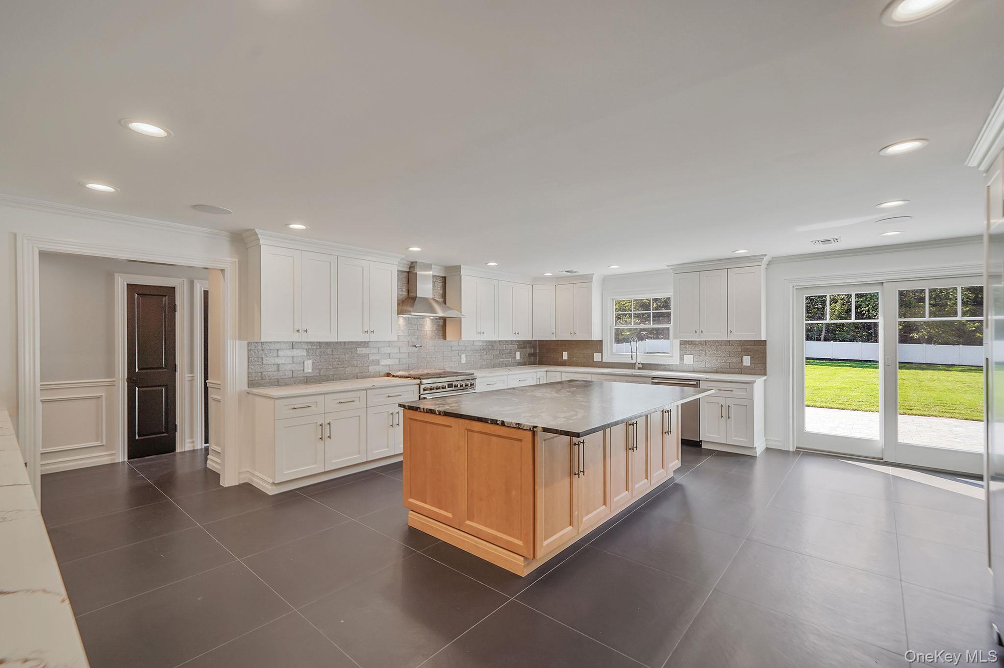 14 Quintree Lane Melville, NY 11747 - Photo 15 of 46 a large kitchen with a large counter top a sink stainless steel appliances and cabinets