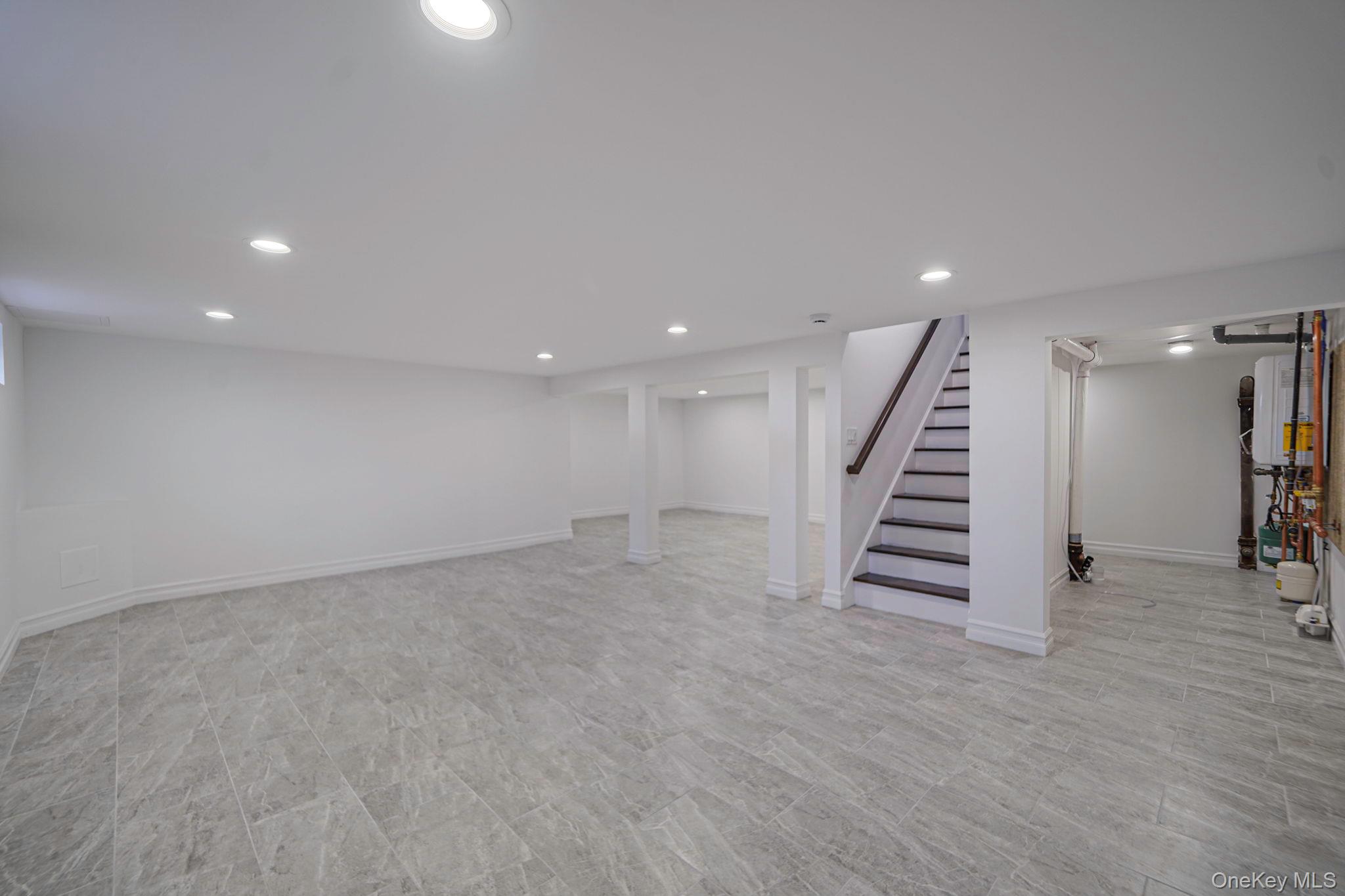 14 Quintree Lane Melville, NY 11747 - Photo 39 of 46 an empty room with wooden floor and stairs