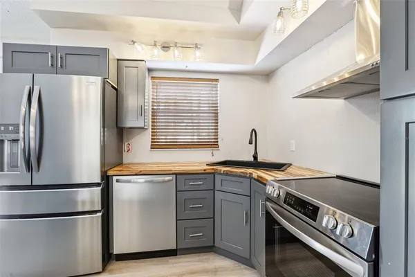 a kitchen with stainless steel appliances granite countertop a refrigerator and a sink
