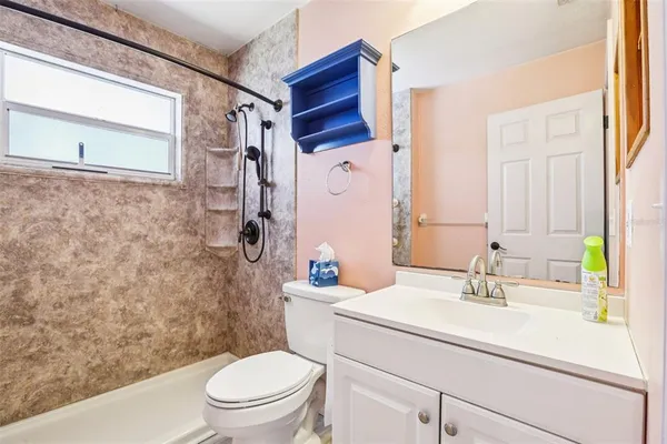 a bathroom with a sink toilet vanity and shower