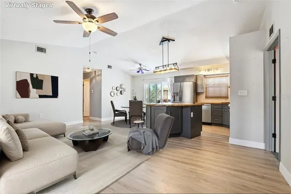 a living room with furniture a chandelier and a dining table