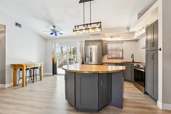 a kitchen with stainless steel appliances granite countertop a kitchen island a stove a refrigerator a sink and dishwasher