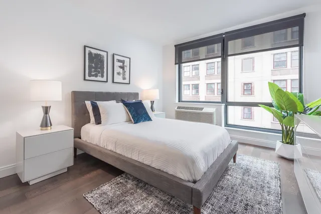 a bedroom with a large bed and a potted plant
