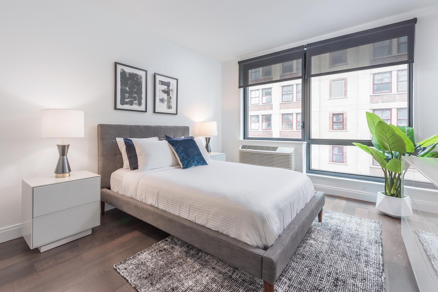 148 1st Street, Unit 809 Jersey City, NJ 07302 - Photo 19 of 20 a bedroom with a large bed and a potted plant