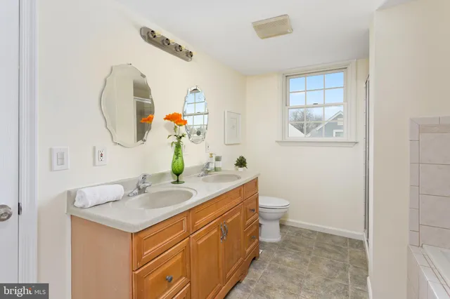 a bathroom with a tub sink and mirror