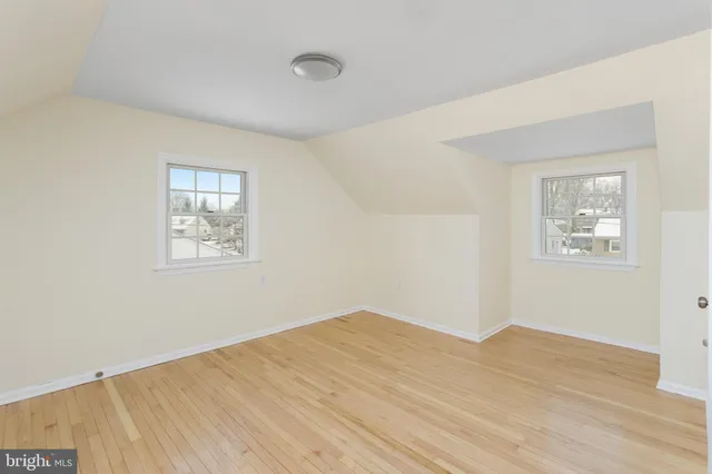 a view of a big room with wooden floor and windows
