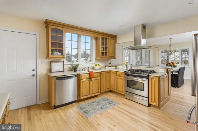 a kitchen with a sink stove and wooden floor