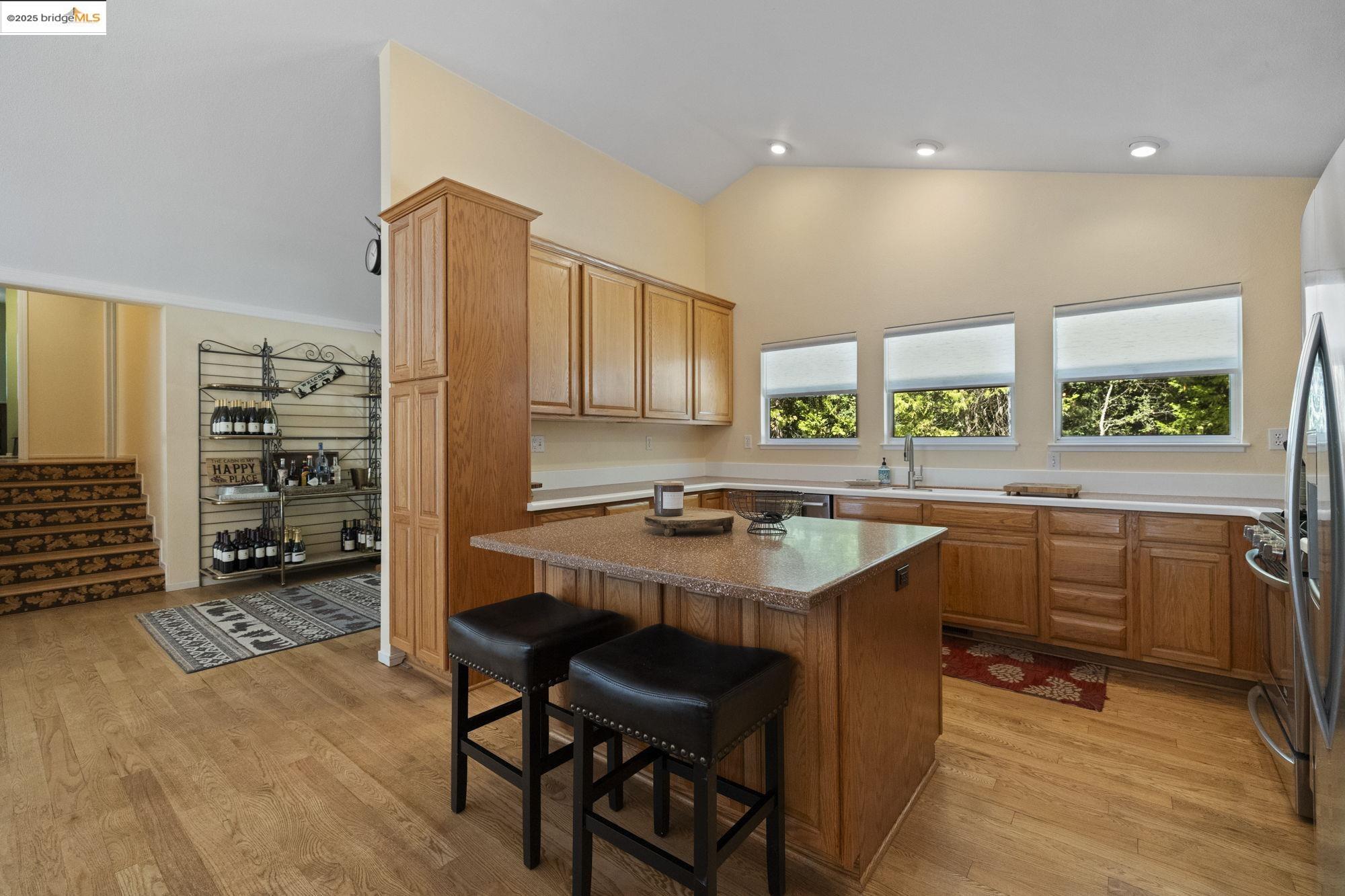 18080 Little Fuller Road Twain Harte, CA 95383 - Photo 11 of 40 Kitchen featuring a breakfast bar area, a kitchen island, vaulted ceiling, light wood-type flooring, and appliances with stainless steel finishes
