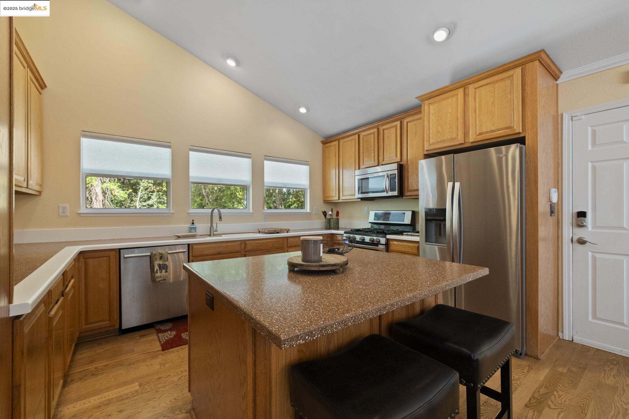 18080 Little Fuller Road Twain Harte, CA 95383 - Photo 12 of 40 Kitchen featuring stainless steel appliances, a center island, light wood-type flooring, a breakfast bar, and vaulted ceiling