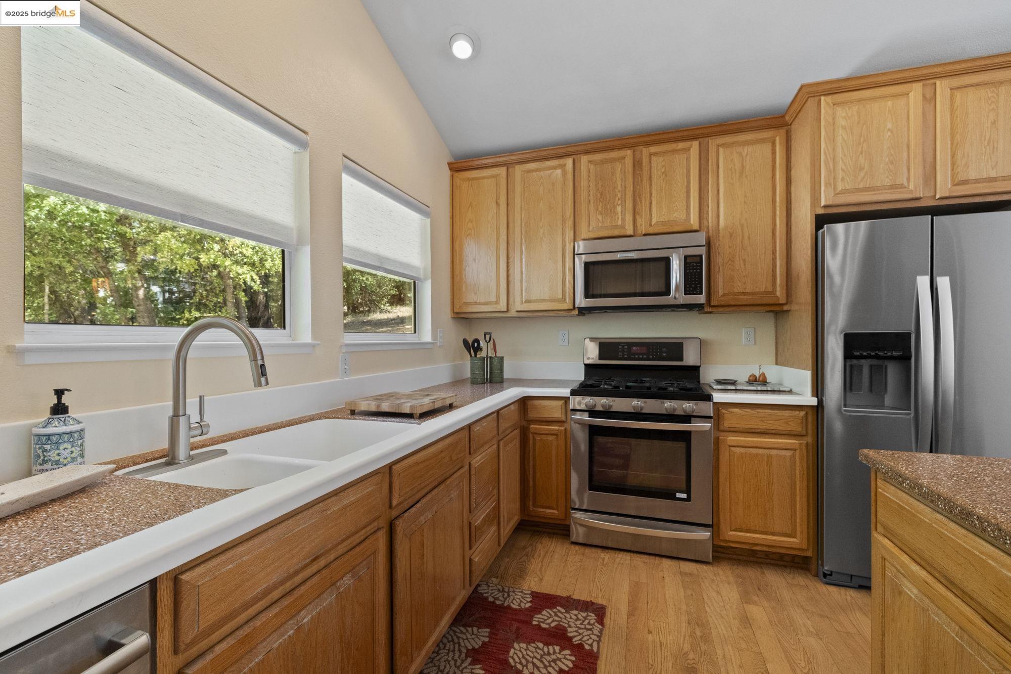18080 Little Fuller Road Twain Harte, CA 95383 - Photo 13 of 40 Kitchen with appliances with stainless steel finishes, light wood-type flooring, light countertops, recessed lighting, and brown cabinetry