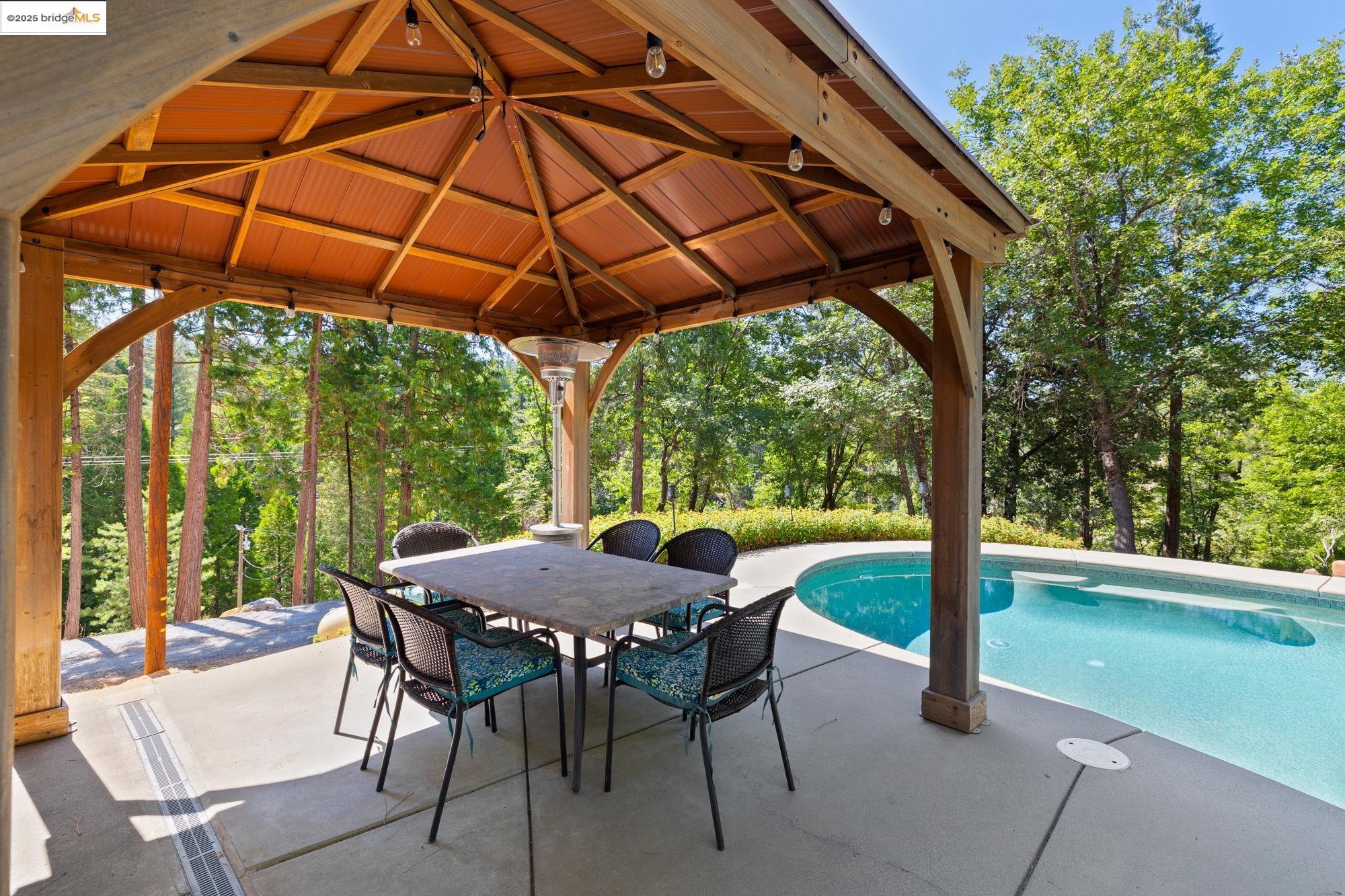 18080 Little Fuller Road Twain Harte, CA 95383 - Photo 3 of 40 Outdoor pool featuring a patio, outdoor dining space, and view of wooded area
