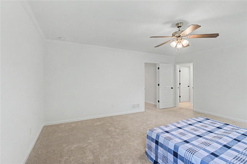 2310 Portrush Way Southeast Atlanta, GA 30339 - Photo 29 of 38 a bedroom with a bed and a chandelier fan