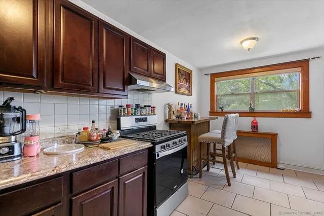 a kitchen with stainless steel appliances granite countertop a sink stove and cabinets