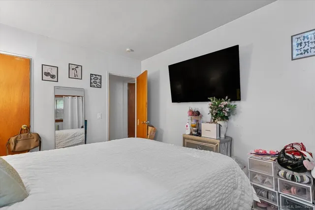 a bedroom with a bed and a flat screen tv