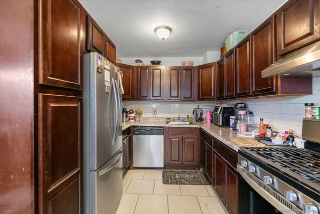 a kitchen with stainless steel appliances granite countertop a refrigerator stove and sink