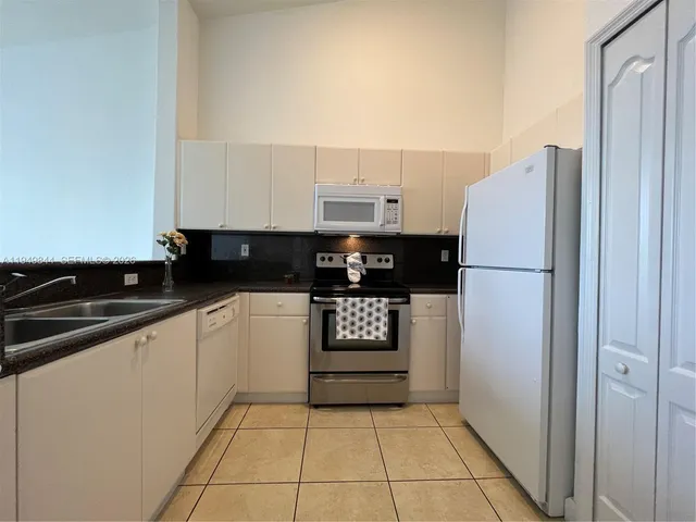 a kitchen with a refrigerator and a stove top oven