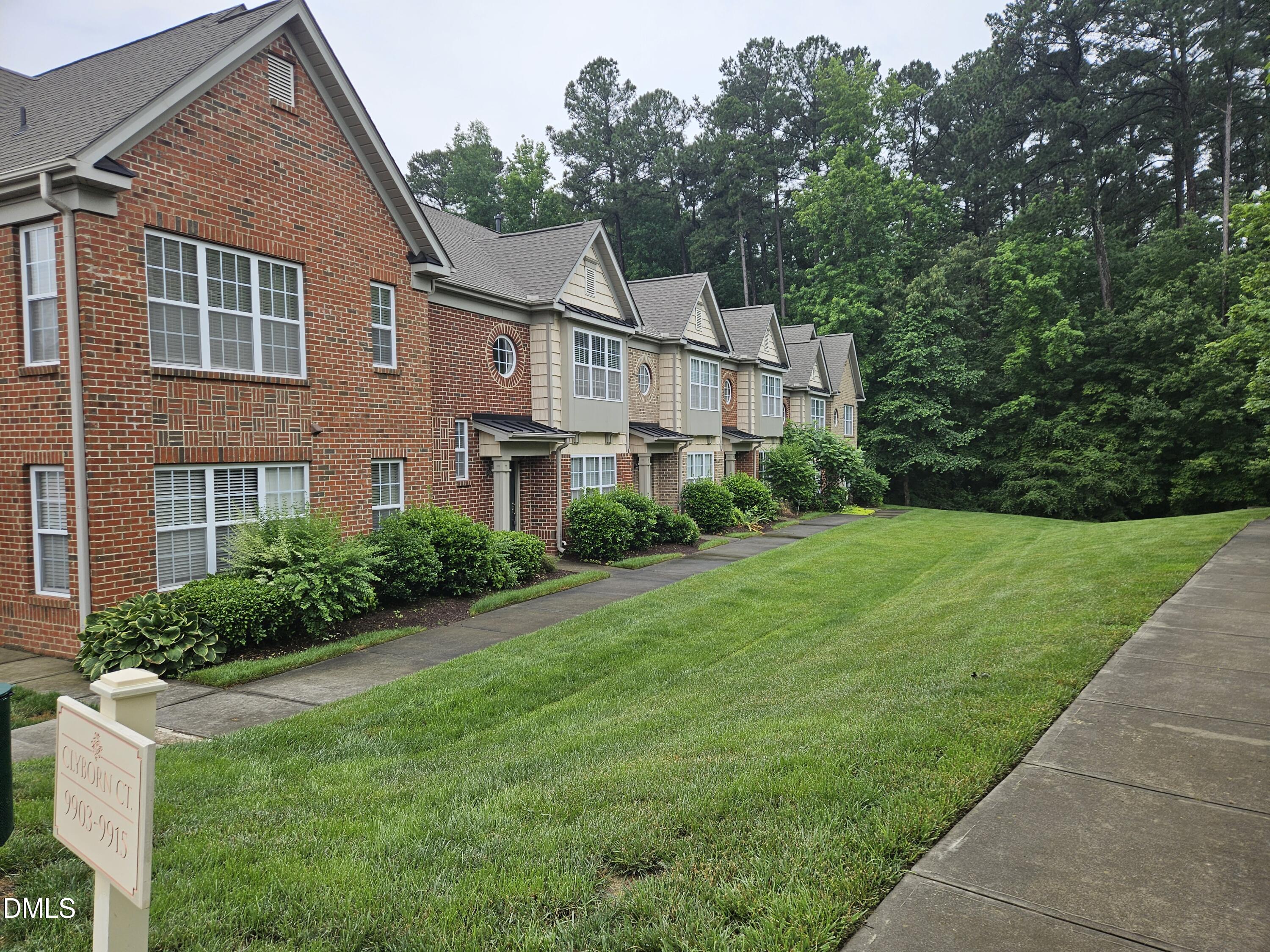 9904 Layla Avenue Raleigh, NC 27617 - Photo 2 of 19 a view of a white house next to a yard with big trees
