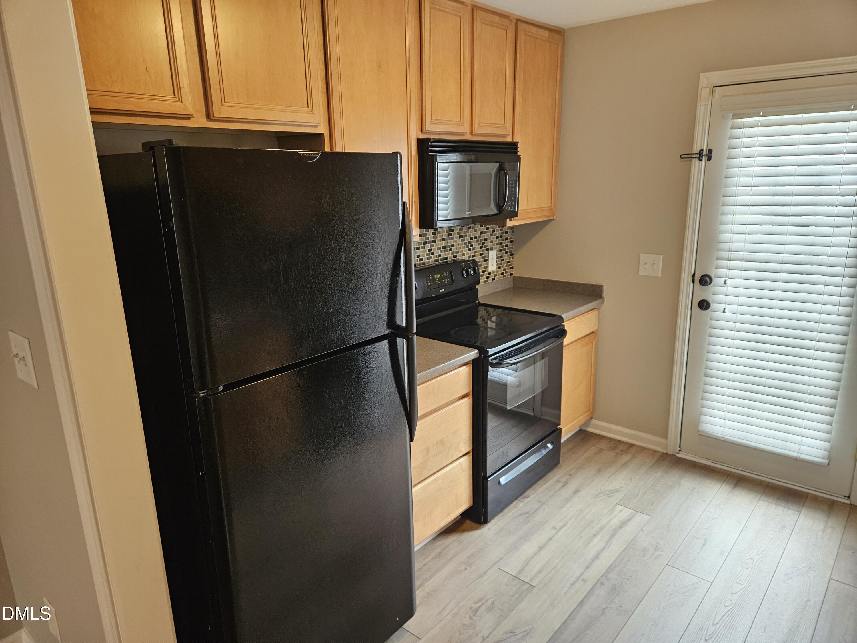 9904 Layla Avenue Raleigh, NC 27617 - Photo 7 of 19 a kitchen with a refrigerator a stove a microwave and cabinets