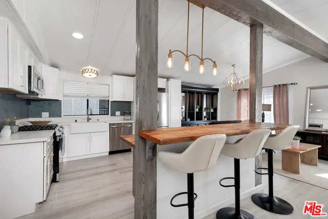 a kitchen with stainless steel appliances granite countertop a stove a sink dishwasher and a refrigerator with wooden floor