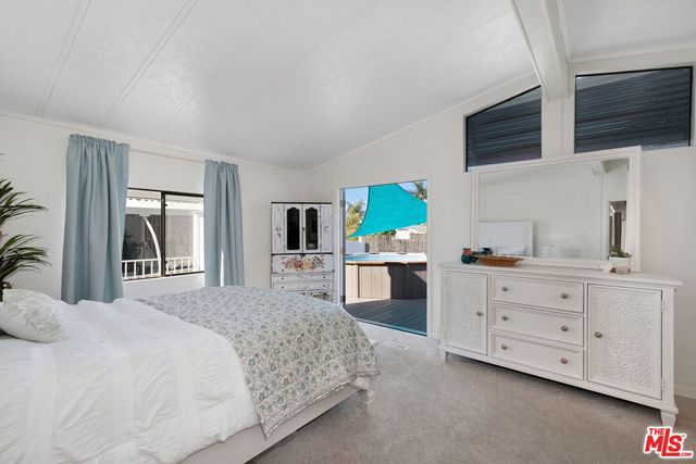 a bedroom with a bed a flat screen tv and dresser