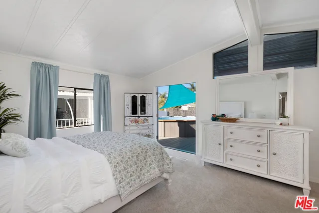 a bedroom with a bed a flat screen tv and dresser