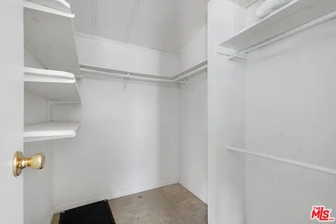 a view of walk in closet with empty racks