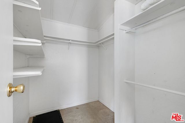 a view of walk in closet with empty racks