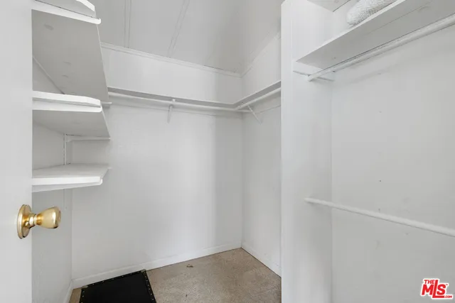 a view of walk in closet with empty racks