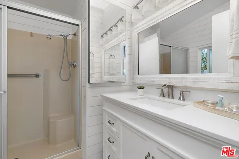 a bathroom with a shower sink vanity and mirror