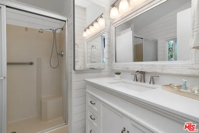 a bathroom with a shower sink vanity and mirror
