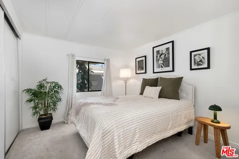 a bedroom with a bed and a potted plant