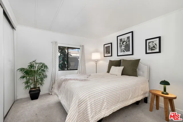 a bedroom with a bed and a potted plant