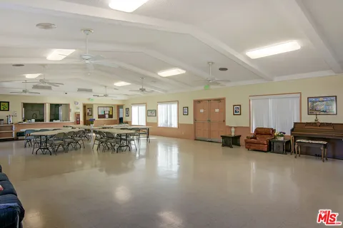 a living room with furniture and a dining table with wooden floor